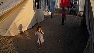 Palestinian children displaced by the Israeli bombardment of the Gaza Strip walk in a UNDP-provided tent camp in Khan Younis on Thursday, Oct. 19, 2023.