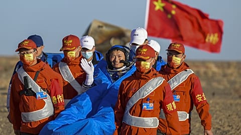 Astronaut Gui Haichao waves as he is carried out of the re-entry capsule of the Shenzhou-14 manned space mission