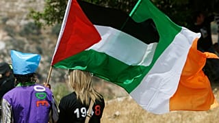 متظاهرون يلوحون بالأعلام الفلسطينية والأيرلندية، في قرية بلعين بالضفة الغربية.