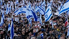 DOSYA - 22 Ekim 2023 Pazar günü Londra'daki Trafalgar Meydanı'nda düzenlenen protesto gösterisinde insanlar İsrail bayrakları ve Gazze'de rehin alındığına inanılan kişilerin resimlerini taşıdı. 