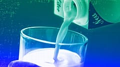 A person pours milk into a glass