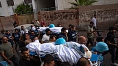 فلسطينيون، بما في ذلك بعض الصحفيين، يحملون جثتي صحفيين فلسطينيين، محمد صبح وسعيد الطويل، اللذين قُتلا في غارة جوية إسرائيلية في مدينة غزة، الثلاثاء 10 أكتوبر 2023.