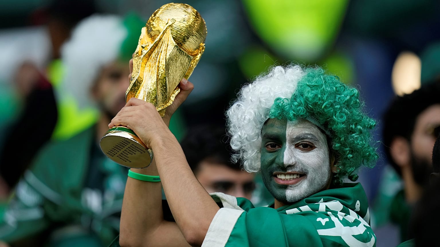 مشجع سعودي يحمل نسخة من كأس العالم 