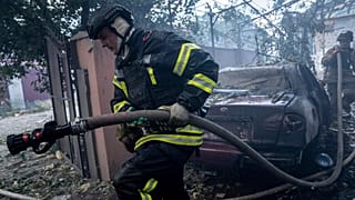 In this photo provided by the Ukrainian Emergency Service, emergency services personnel work to extinguish a fire in Kherson, Ukraine, on Monday, Oct. 30, 2023,