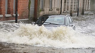 A car drives through flood water on Canal Quay in Newry Town, Co Down, which has been swamped by floodwater as the city's canal burst its banks amid heavy rainfall.