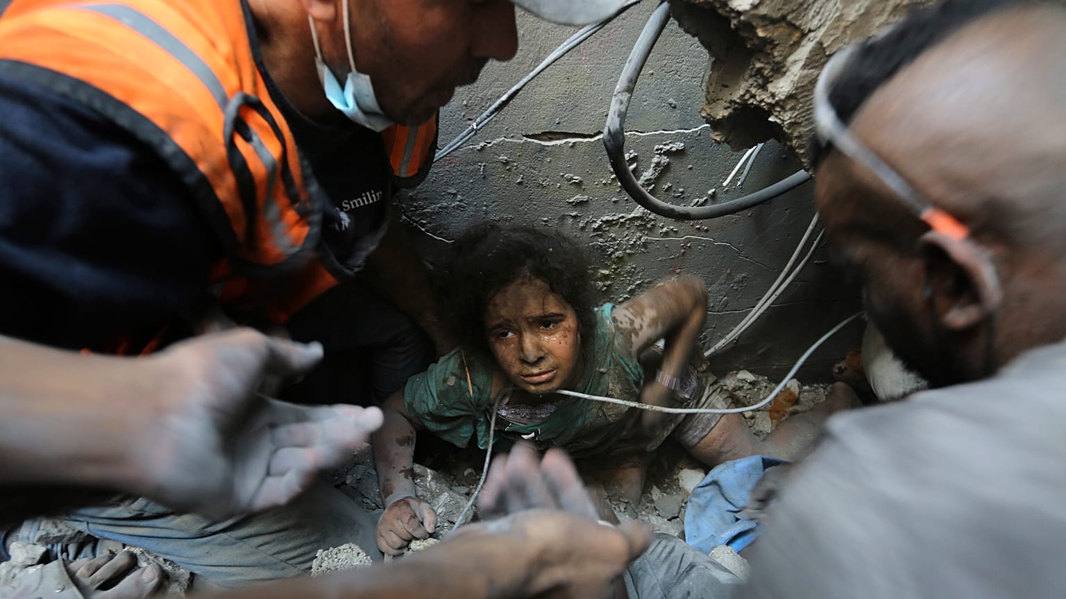 فلسطينيون يحاولون انتشال فتاة من تحت أنقاض مبنى دمرته الغارات الجوية الإسرائيلية في مخيم جباليا للاجئين