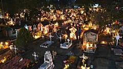 People gather in the section of children's tombs inside the San Gregorio Atlapulco cemetery during Day of the Dead festivities on the outskirts of Mexico City, early Wednesday
