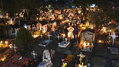 People gather in the section of children's tombs inside the San Gregorio Atlapulco cemetery during Day of the Dead festivities on the outskirts of Mexico City, early Wednesday