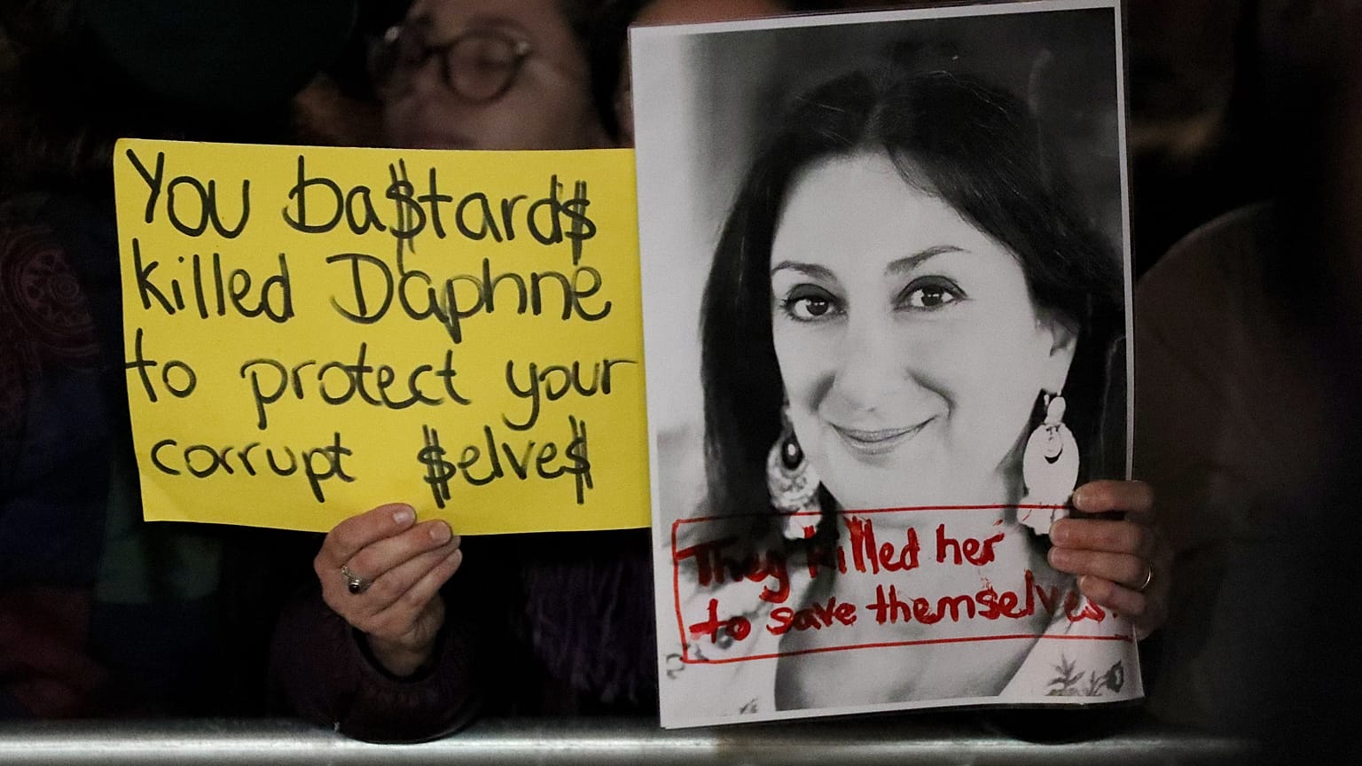 Tüntetők a vallettai parlament előtt a meggyilkolt máltai újságíró, Daphne Caruana Galizia fotójával 2019. november 26-án.