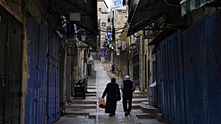 فلسطينيون يسيرون بجوار المتاجر المغلقة في البلدة القديمة بالقدس، الاثنين 16 أكتوبر 2023