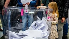 Une fille glisse un bulletin dans une urne lors des élections législatives en Pologne