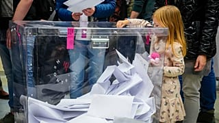 Une fille glisse un bulletin dans une urne lors des élections législatives en Pologne