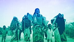 Somalis who fled drought-stricken areas carry their belongings as they arrive at a makeshift camp for the displaced on the outskirts of Mogadishu, June 2022