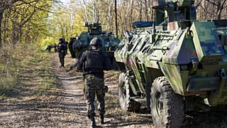 Serbian gendarmerie officers looking for migrants in a forest near the border between Serbia and Hungary, Serbia, Thursday, Nov. 2, 2023.