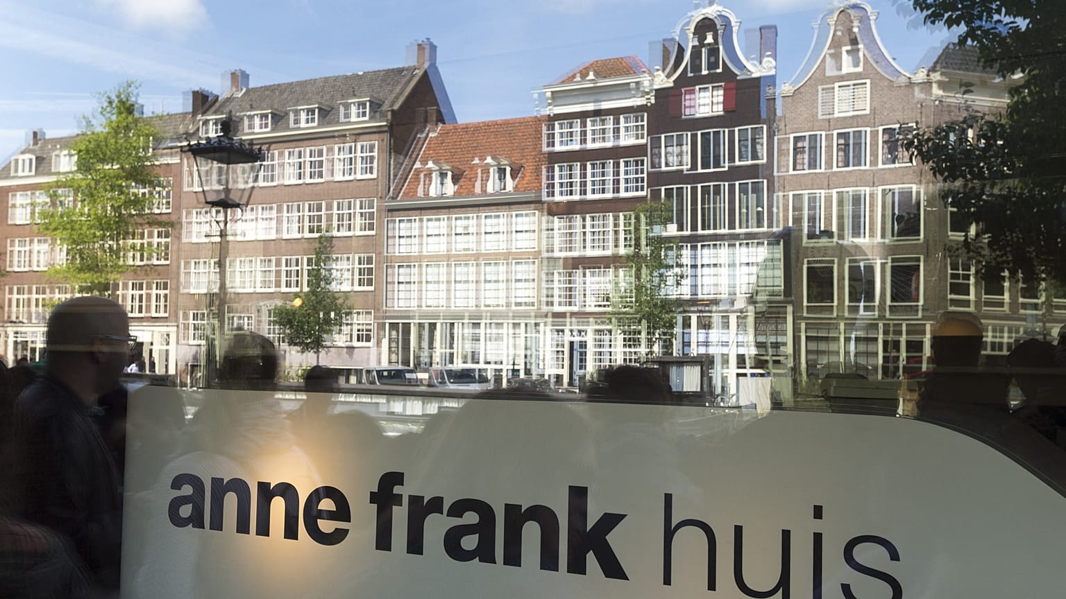 Tourists are reflected in the window of the Anne Frank house in Amsterdam, on June 15, 2015. 