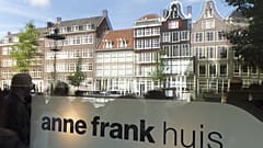 Tourists are reflected in the window of the Anne Frank house in Amsterdam, on June 15, 2015. 