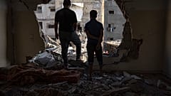 Palestinians look at the destruction after Israeli strikes on the Gaza Strip in Khan Younis on Saturday
