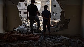 Palestinians look at the destruction after Israeli strikes on the Gaza Strip in Khan Younis on Saturday