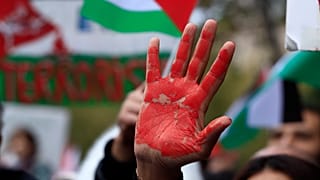 متظاهر في باريس صبغ كفه باللون الاحمر 