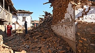 A man looks at damaged houses in the aftermath of an earthquake at Jajarkot district on Saturday