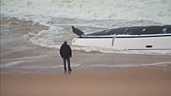 Ein Mann blickt auf das verunglückte Segelboot.