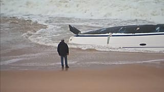 Ein Mann blickt auf das verunglückte Segelboot.