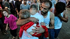 أب فلسطيني يحمل طفلاً صغيرًا إلى مستشفى الشفاء عقب قصف الجيش الإسرائيلي لمنزل في حي المنصورة بمدينة غزة.