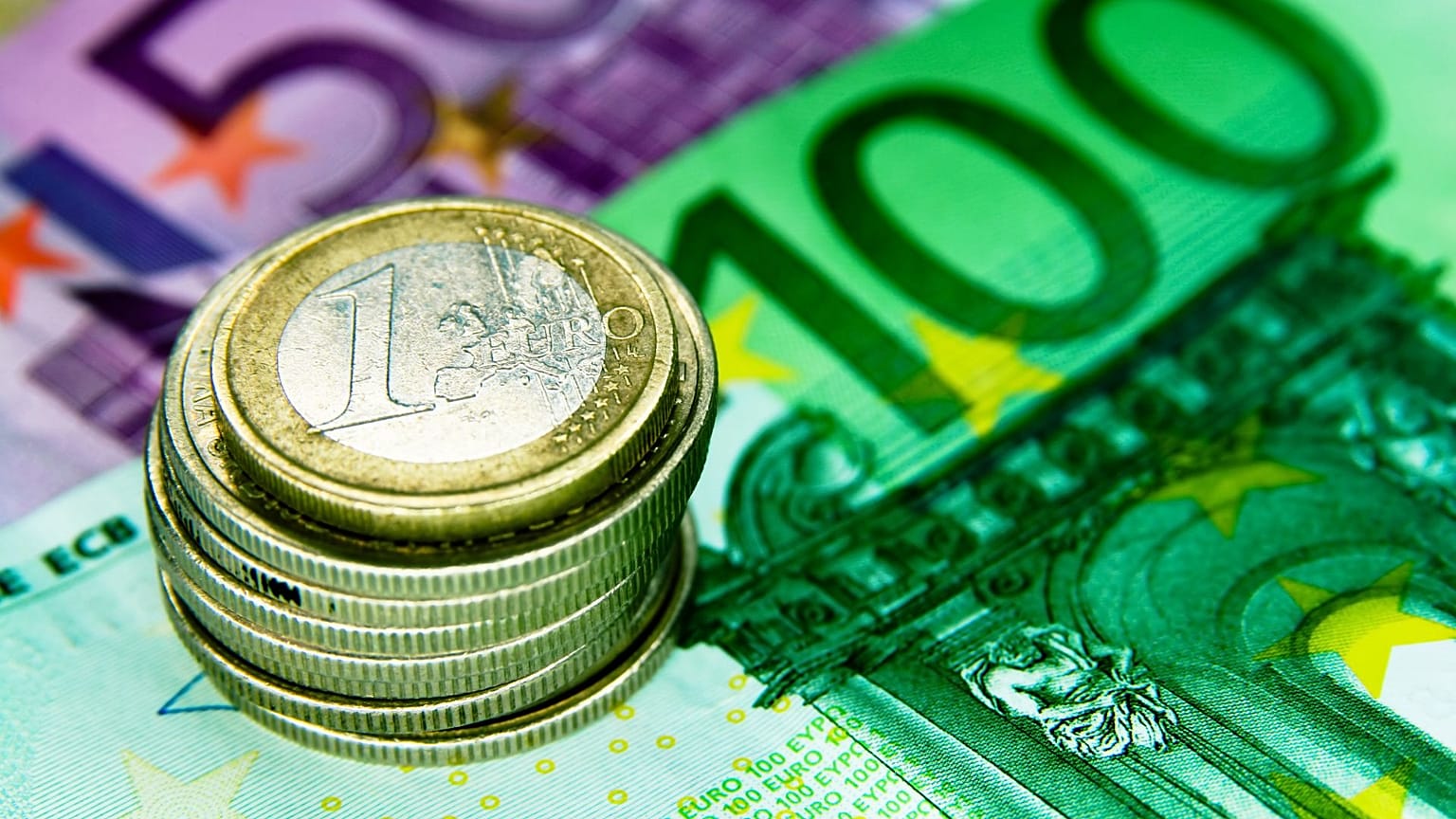 Moedas de euro empilhadas sobre notas de euro
