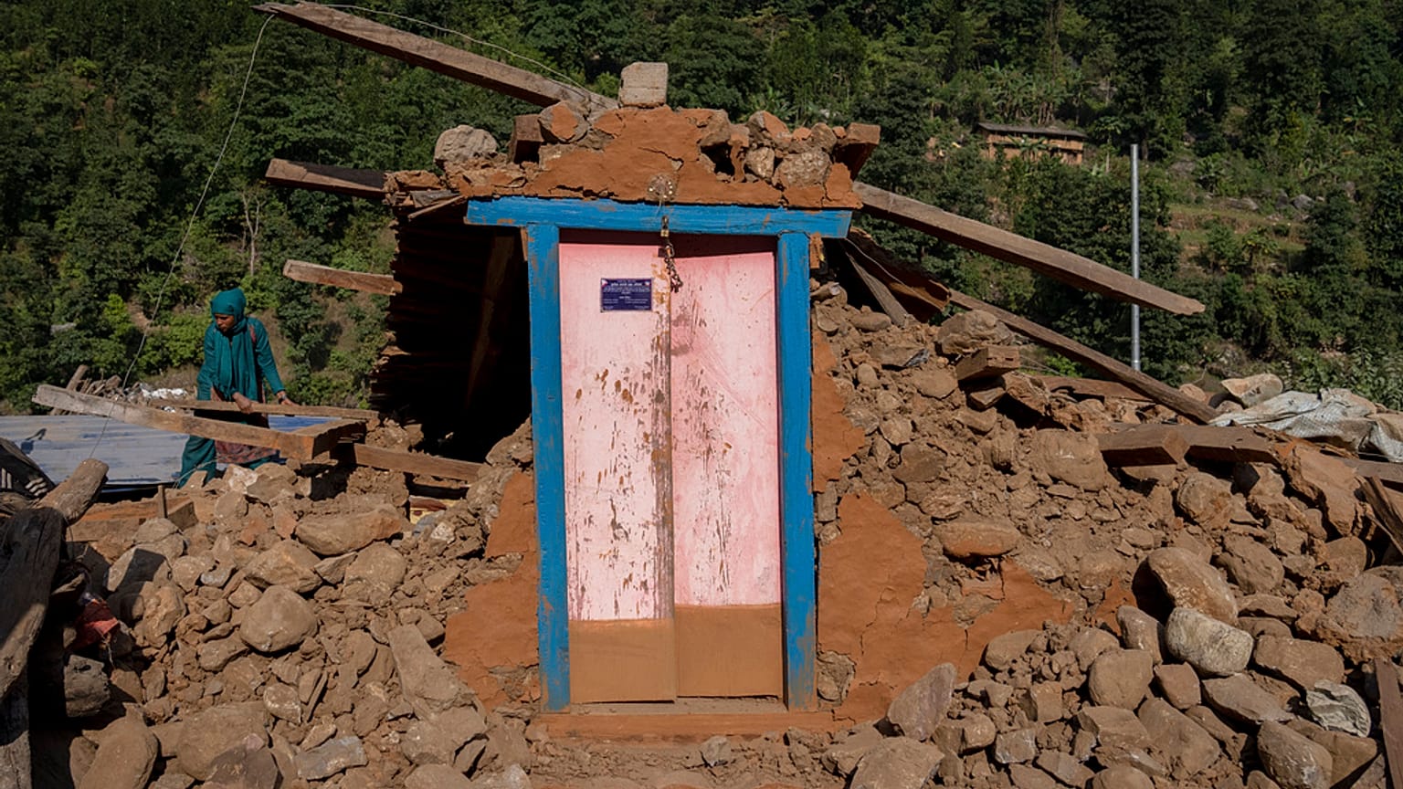 Una superviviente trata de recuperar bienes entre los escombros al noroeste de Nepal este lunes