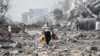 Местные жители на руинах в секторе Газа