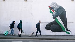 Emberek sétálnak Emmalene Blake művész palesztinbarát falfestménye mellett Dublin Harold's Cross negyedében, Írországban.