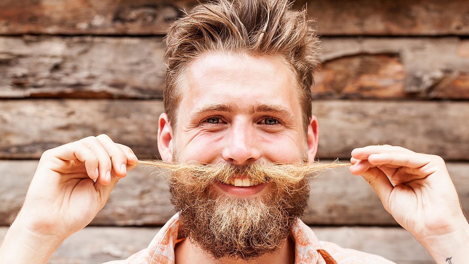 A man twiddles his moustache