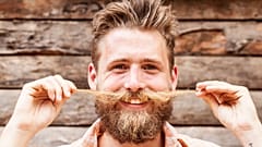 A man twiddles his moustache