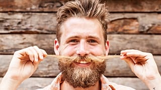 A man twiddles his moustache