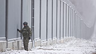 ARCHIVO - Un guardia fronterizo polaco junto al muro fronterizo en Nomiki, Polonia, en noviembre de 2022\.