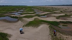 Les habitants d'une communauté riveraine transportent de la nourriture et des récipients d'eau potable en raison de la sécheresse persistante et des températures élevées qui a