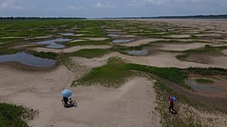 Les habitants d'une communauté riveraine transportent de la nourriture et des récipients d'eau potable en raison de la sécheresse persistante et des températures élevées qui a