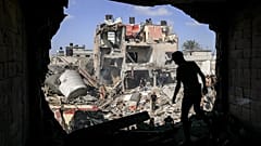 A youth stands before a hole in what used to be a wall in a building that was hit during Israeli bombardment n the southern Gaza Strip on November 8, 2023.