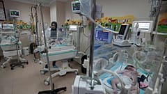 طاقم طبي يعالج طفلًا في مستشفى الأقصى في دير البلح بقطاع غزة. 