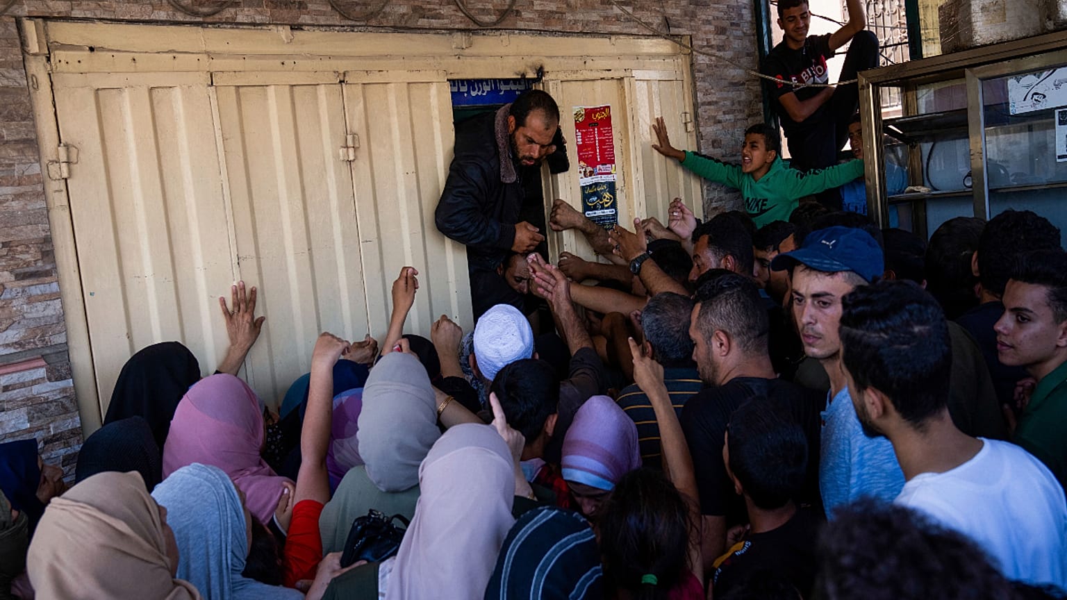 فلسطينيون يصطفون لشراء الخبز أمام مخبر في خان يونس، قطاع غزة.