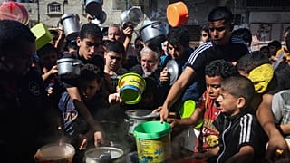 Palestinians crowded together as they wait for food distribution in Rafah, southern Gaza Strip, Wednesday, Nov. 8, 2023.