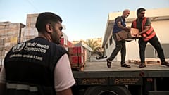 فلسطينيون يفرغون صناديق أدوية من شاحنة وصلت إلى مجمع ناصر الطبي