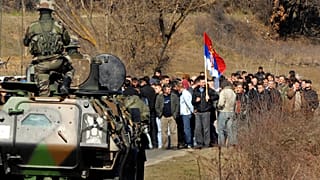 FILE: A KFOR soldier from France looks at Kosovar Serbs blocking the road connecting Serbia with the ethnically divided town of Kosovska Mitrovica, near Cabra, Kosovo.