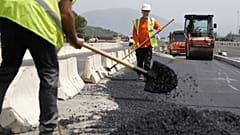 Employees are at work on a road construction under 39 degres Celcius during a heat wave the French Mediterranean island of Corsica, outside Ajaccio on June 21, 2023.
