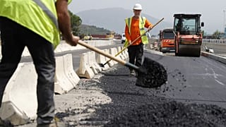 Employees are at work on a road construction under 39 degres Celcius during a heat wave the French Mediterranean island of Corsica, outside Ajaccio on June 21, 2023.