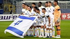 لاعبو مكابي تل أبيب يرفعون العلم الإسرائيلي  قبل مباراة كرة القدم بين زوريا لوهانسك ومكابي تل أبيب في المجموعة ب من دوري أوروبا للمؤتمرات في ملعب أرينا لوبلين في بولندا