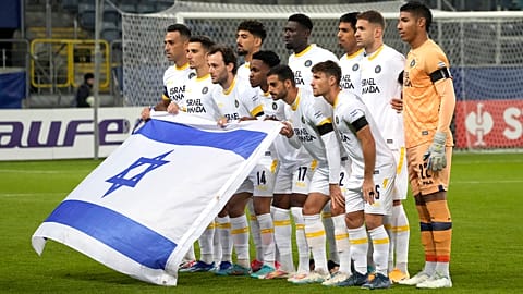 لاعبو مكابي تل أبيب يرفعون العلم الإسرائيلي  قبل مباراة كرة القدم بين زوريا لوهانسك ومكابي تل أبيب في المجموعة ب من دوري أوروبا للمؤتمرات في ملعب أرينا لوبلين في بولندا