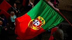 A Portuguese flag is carried among people in Lisbon protesting the rising cost of living, Thursday, Feb. 9, 2023. 