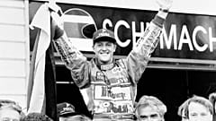 German F1 racing driver Michael Schumacher waves a German flag as he is hoisted by his pit crew at the Australian Grand Prix track in Adelaide in this Nov.13, 1994 file photo