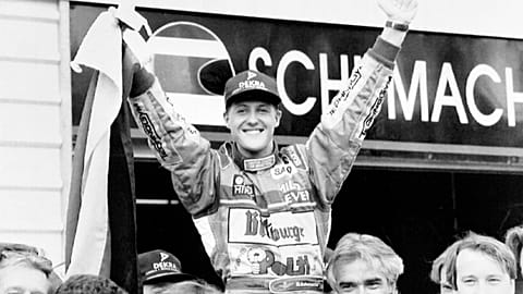 German F1 racing driver Michael Schumacher waves a German flag as he is hoisted by his pit crew at the Australian Grand Prix track in Adelaide in this Nov.13, 1994 file photo